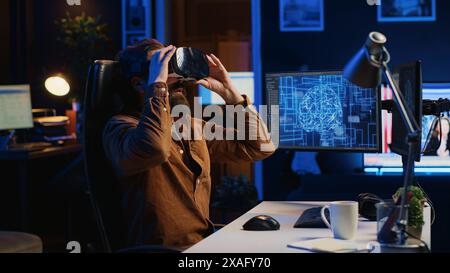 Informaticien portant des lunettes VR paniquant après que l'IA gagne en omniscience, jetant des lunettes et programmant un pare-feu. Programmeur effrayé par l'intelligence artificielle gagnant l'illumination, caméra A. Banque D'Images