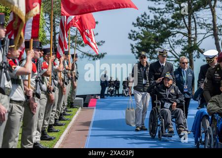 Colleville-sur-mer, France. 06 juin 2024. Un vétéran de la seconde Guerre mondiale salue alors qu’il passe le cordon d’honneur de l’armée française avant le début du 80e anniversaire du débarquement au cimetière américain de Normandie, le 6 juin 2024, à Colleville-sur-mer, France. Crédit : Cameron Smith/White House photo/Alamy Live News Banque D'Images