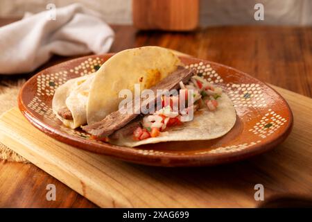 Arrachera Tacos. Steak de bœuf mariné servi dans une tortilla de blé sur une assiette d'argile mexicaine. Cuisine de rue du Mexique, traditionnellement accompagnée de cila Banque D'Images