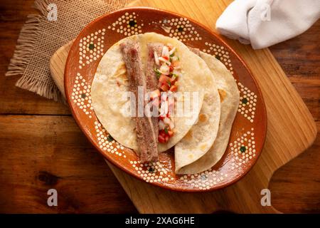 Arrachera Tacos. Steak de bœuf mariné servi dans une tortilla de blé sur une assiette d'argile mexicaine. Cuisine de rue du Mexique, traditionnellement accompagnée de cila Banque D'Images