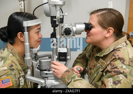 14 mai 2024 - Schofield Barracks, Hawaii, États-Unis - Major Adrian Hulbert, à droite, optométriste du 110e Groupe médical (MDG), examine les yeux de la sergt Mary de Guzman, à gauche, patient de la clinique de santé Desmond T. Doss, au cours de la formation annuelle de l'établissement médical (MFAT) du 110e OMD à Schofield Barracks, Hawaii, le 14 mai 2024. Le MFAT offre des possibilités de formation en cours d'emploi essentielles aux gardiens, qui ont la chance d'apprendre du personnel militaire en service actif, d'acquérir une expérience précieuse et de ramener leurs connaissances nouvellement acquises à la base a de la Garde nationale aérienne de Battle Creek Banque D'Images