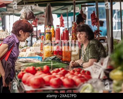 Photo de deux femmes discutant, une commerçante, une cliente, au marché zeleni venac, serbie. Zeleni Venac Market est un marché fermier important situé i Banque D'Images