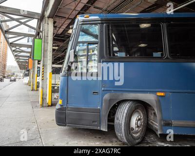 Un bus longue distance est garé et prêt pour le départ dans une gare routière très fréquentée en Amérique du Nord. L'image capture l'essence des transports en commun Banque D'Images