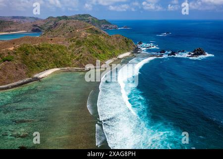 Vue aérienne des vagues se brisant contre un récif corallien frangeant à côté d'une plage tropicale de sable Banque D'Images