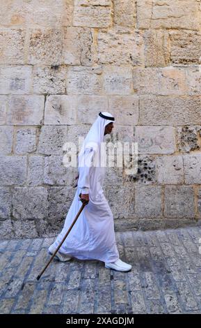 Un arabe habillé traditionnellement marchant dans le quartier musulman de la vieille ville de Jérusalem. Banque D'Images