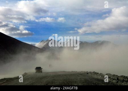 Conduite à travers les tempêtes de sable dans les montagnes du Pamir à la frontière de la Chine et du Tadjikistan. Banque D'Images