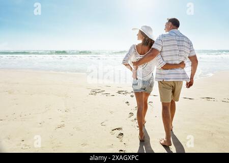 Les gens, retour et marcher sur la plage ensemble en escapade, vacances d'été et relation de liaison pour l'engagement. Marié, couple et océan tropical Banque D'Images