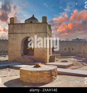 Bakou, Azerbaïdjan - 9 mai 2024 : vue du temple du feu Ateshgah. Le temple est éclairé par le soleil couchant, et un feu brûle au premier plan Banque D'Images