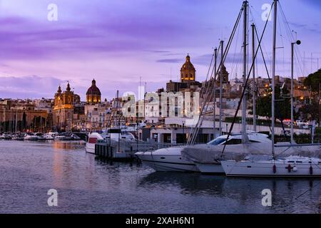 Birgu ville, une partie des trois villes de Malte. La marina nocturne brille sous le ciel nocturne, les mâts de yacht se silhouettent contre les lumières scintillantes qui se réfléchissent Banque D'Images
