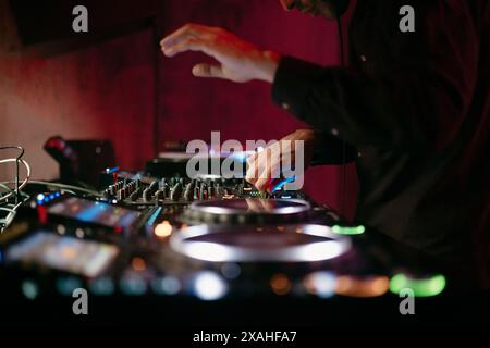 Vue rapprochée des mains d'un dj jouant la table de mixage pendant l'exécution Banque D'Images