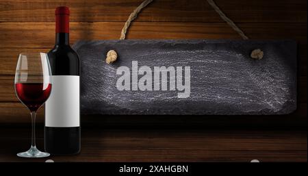 Image de lumières sur une bouteille et un verre de vin rouge sur fond de bois avec étiquette Banque D'Images