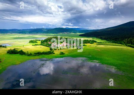 Village Otok (île) près du lac Cerknica, le plus grand lac intermittent de toute l'Europe, entouré d'une forêt luxuriante, Slovénie Banque D'Images