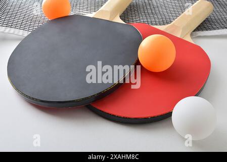 Fond avec jeu de pagaies de tennis de table, filet et boule orange isolé sur table blanche. Vue surélevée. Banque D'Images