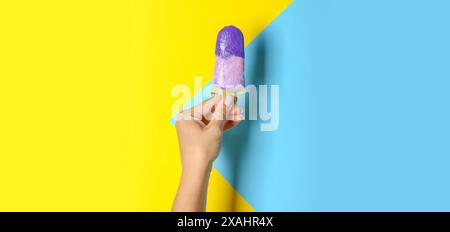Main avec une savoureuse crème glacée à la myrtille sur fond de couleur Banque D'Images