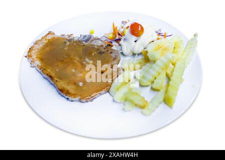 Découpez à l'emporte-pièce du steak de bœuf grillé avec du français frit sur une plaque blanche sur blanc isolé. Banque D'Images