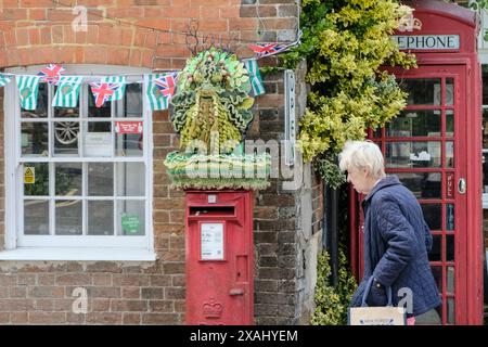 Avebury, Royaume-Uni. 7 juin 2024. Un topper de boîte postale tricoté Green Man est arrivé à Avebury. Le village célèbre pour être placé dans un cercle de pierre préhistorique attire de nombreuses personnes intéressées par les modes de vie naturels ainsi que les touristes conventionnels. L'homme vert est censé représenter le cycle de la vie, de la mort et de la renaissance. Crédit : JMF News/Alamy Live News Banque D'Images