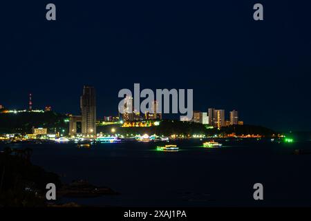 Vue de la lumière colorée du bâtiment et du bateau dans la mer de Pattaya dans la nuit. Pattaya est l'une des plus célèbres stations balnéaires de Thaïlande. Banque D'Images