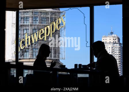 Le panneau publicitaire Schweppes sur le bâtiment Carrion vu d'un café dans la salle de restauration du centre commercial El Corte Ingles sur la Plaza de Callao, Banque D'Images