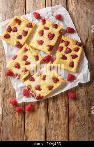 Tarte aux baies allemande maison avec framboise et crème anglaise en gros plan sur le papier sur la table en bois. Vue de dessus verticale Banque D'Images