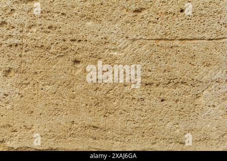 photographie à plat en gros plan d'une surface de grès jaune beige, fond texturé de roche de sable antique Banque D'Images