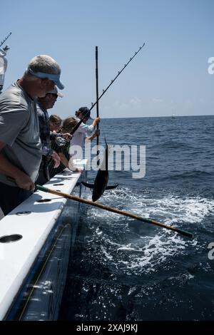 Un pêcheur à la ligne défile dans un thon capturé près de plates-formes pétrolières flottantes dans le golfe du Mexique, illustrant la juxtaposition de la pêche récréative et du pétrole au large Banque D'Images