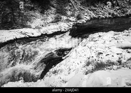 Paysage de cascade enneigée, photo noir et blanc. Chutes de Kivach un jour d'hiver froid et nuageux. Rivière Suna, district de Kondopoga, République de Kareli Banque D'Images