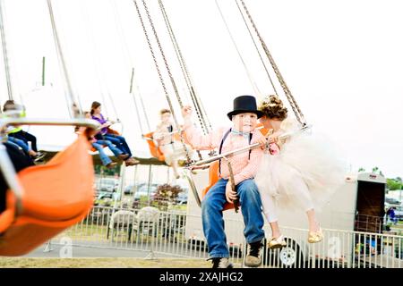 Enfants en costumes appréciant une balade à un carnaval, plein o Banque D'Images