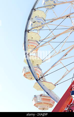 Gros plan d'une grande roue contre un ciel bleu clair à une carniva Banque D'Images