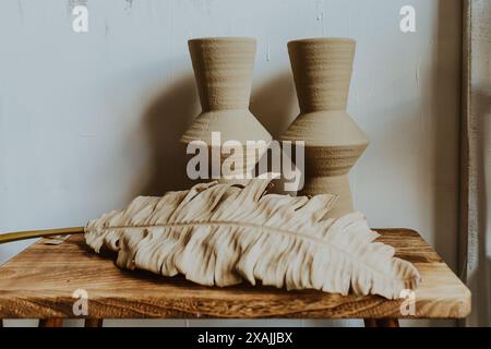 deux vases assis sur une table en bois avec feuille de palmier Banque D'Images