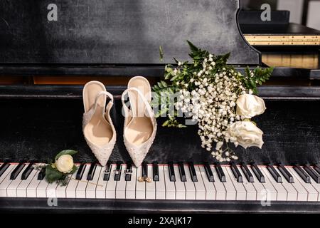 Chaussures de mariage, bagues et bouquet affichés sur un clavier de piano Banque D'Images