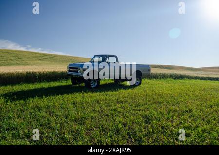 Camion classique face au lever du soleil sur des collines ondulantes Banque D'Images