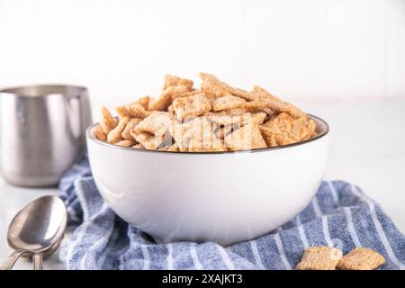 Mélange croquant pour toasts à la cannelle dans un bol en portions avec du lait. Céréales pour petit déjeuner à la cannelle crunchy sucrées et tendance Banque D'Images