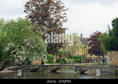 Scène à Bourton-on-the-Water dans le quartier Cotswold dans le Gloucestershire. La rivière Windrush la traverse et est traversée par une série de ponts. Banque D'Images