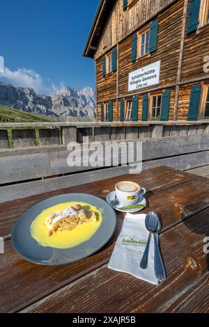 Dolomites, Province de Bolzano, Tyrol du Sud, Italie. Strudel aux pommes et cappuccino sur la terrasse de la cabane Schlüterhütte Banque D'Images