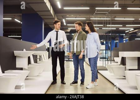 Couple regardant des toilettes à chasse d'eau tout en magasinant pour des appareils sanitaires au magasin de plomberie Banque D'Images
