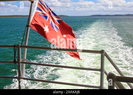 Drapeau australien Red Ensign à l'arrière du ferry Kingfisher Bay, voyageant entre la côte est du Queensland et Fraser Island (K'gari), le larg Banque D'Images