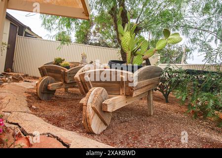 Cactus poussant dans une brouette en bois à l'extérieur de Faye's Underground House, une attraction touristique populaire de Coober Pedy (Australie méridionale) - résidentiel d Banque D'Images