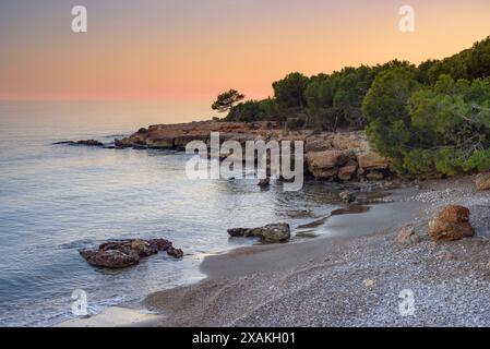 Coucher de soleil d'hiver depuis une crique à Montsià Mar entre la Ràpita et Alcanar, au sud du delta de l'Èbre (Tarragone, Catalogne, Espagne) Banque D'Images