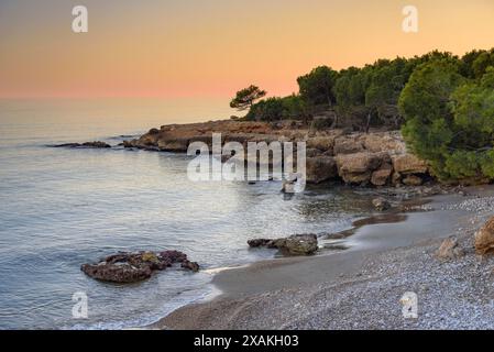 Coucher de soleil d'hiver depuis une crique à Montsià Mar entre la Ràpita et Alcanar, au sud du delta de l'Èbre (Tarragone, Catalogne, Espagne) Banque D'Images