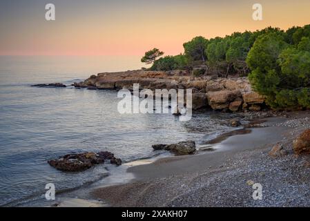 Coucher de soleil d'hiver depuis une crique à Montsià Mar entre la Ràpita et Alcanar, au sud du delta de l'Èbre (Tarragone, Catalogne, Espagne) Banque D'Images