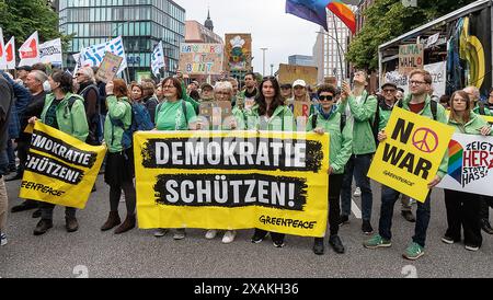 Hambourg, Allemagne. 07 juin 2024. Les membres de Greenpeace tiennent une banderole disant "Protégez la démocratie!" lors d'un grand rassemblement contre l'extrême droite et pour la démocratie. Deux jours avant les élections européennes et de district, une large alliance donne l'exemple à la démocratie sous le slogan "arrêtez l'extrémisme de droite - défendez la démocratie - allez voter!". Crédit : Markus Scholz/dpa/Alamy Live News Banque D'Images