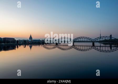 Lever du soleil, ambiance matinale à Riga avec Académie des sciences, pont ferroviaire sur la Daugova, Riga, Lettonie Banque D'Images