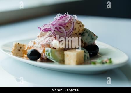 Salade aux herbes, fromage à pâte dure, olives, tomates cerises, oignons, concombres et laitue Banque D'Images