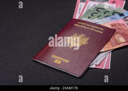 Passeport de la République de France, billets d'avion et argent sur fond de béton foncé. Contexte conceptuel sur le thème du tourisme et des voyages Banque D'Images