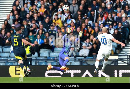 Le finlandais Teemu Pukki (à droite) tente de battre le gardien de but écossais Angus Gunn alors que l'écossais Grant Hanley (à gauche) regarde lors d'un amical international à Hampden Park, Glasgow. Date de la photo : vendredi 7 juin 2024. Banque D'Images