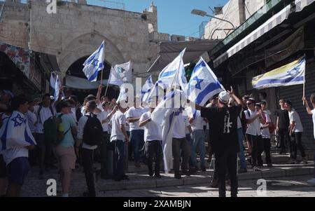 JÉRUSALEM - 5 JUIN : les Israéliens ultra-nationalistes marchent avec des drapeaux israéliens dans la rue Al-Wad dans le quartier musulman lors de la "Marche du drapeau" nationaliste juive pour marquer la "Journée de Jérusalem" dans la vieille ville le 5 juin 2024 à Jérusalem. Israël. La marche annuelle du drapeau de la Journée de Jérusalem attire généralement des milliers d'Israéliens nationalistes qui défilent à travers la ville, y compris le quartier musulman de la vieille ville. Banque D'Images