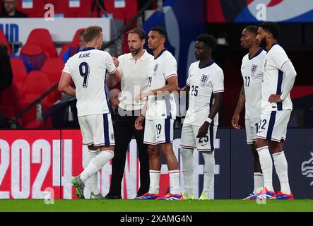 De gauche à droite, l'anglais Harry Kane serre la main de l'entraîneur Gareth Southgate, tandis que les remplaçants Trent Alexander-Arnold, Bukayo Saka, Ivan Toney et Declan Rice attendent lors du match amical international au stade de Wembley, à Londres. Date de la photo : vendredi 7 juin 2024. Banque D'Images