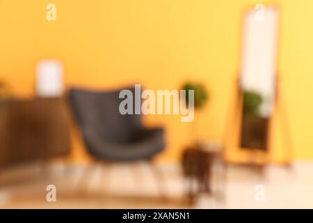 Fauteuil près de la table basse avec livre dans le salon. Vue floue Banque D'Images