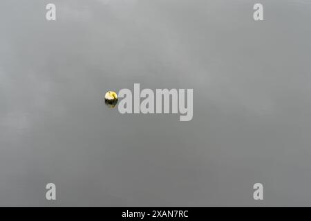 Bateau de rangée sur le lac calme calme avec la réflexion du bateau sur l'eau Banque D'Images