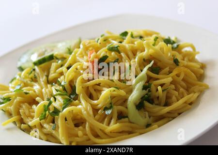 Bami Goreng, mie goreng, nouilles frites indonésiennes sur une assiette blanche. Gros plan. Mise au point sélective. Banque D'Images